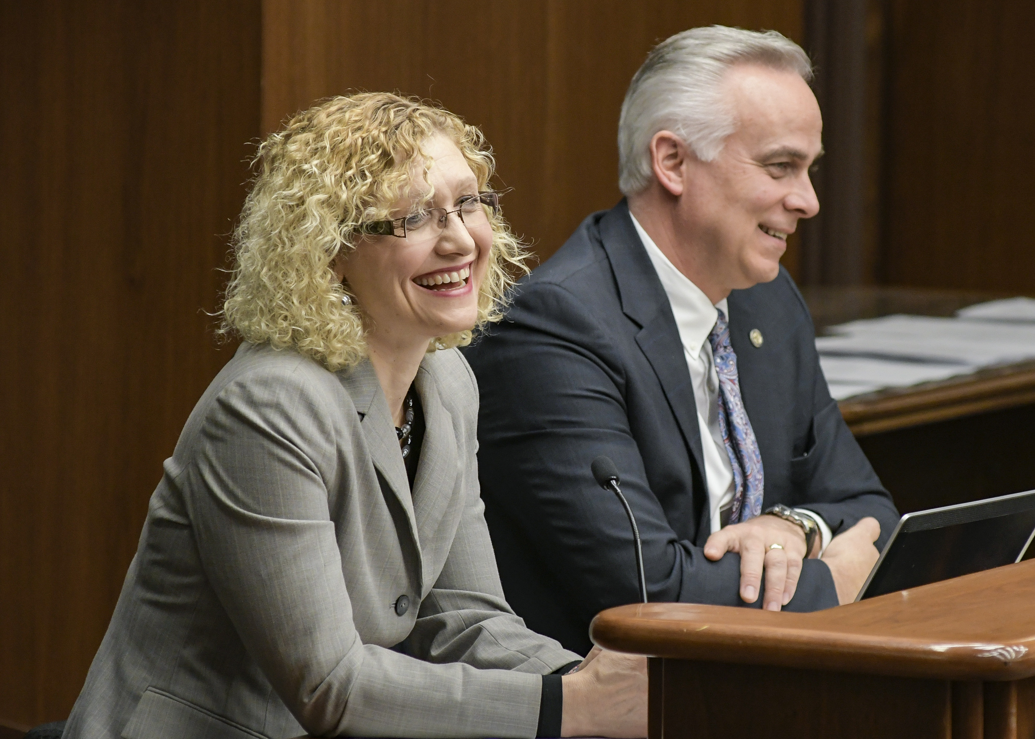 Melissa Lallak, administrator of the Hennepin County Medical Examiner’s Office, testifies before the House Health and Human Services Finance Committee March 22 in support of a bill sponsored by Rep. Tony Albright, right. Photo by Andrew VonBank
